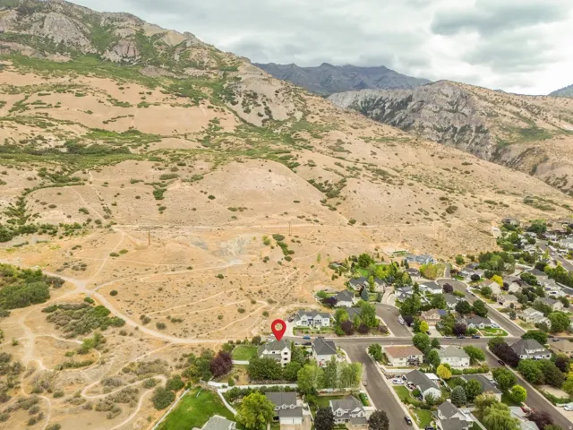Residential neighborhood with established streets and mature landscaping, set against a backdrop of mountainous terrain