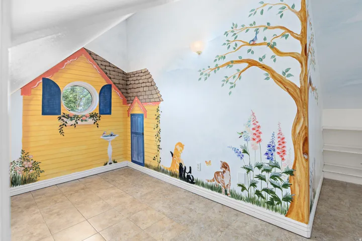 Room featuring extensive wall murals, a rounded window with blue shutters, a bird bath motif, and light-toned tile flooring