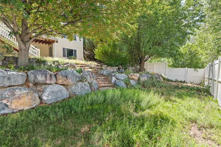 Tiered landscaping featuring large boulders and stone steps