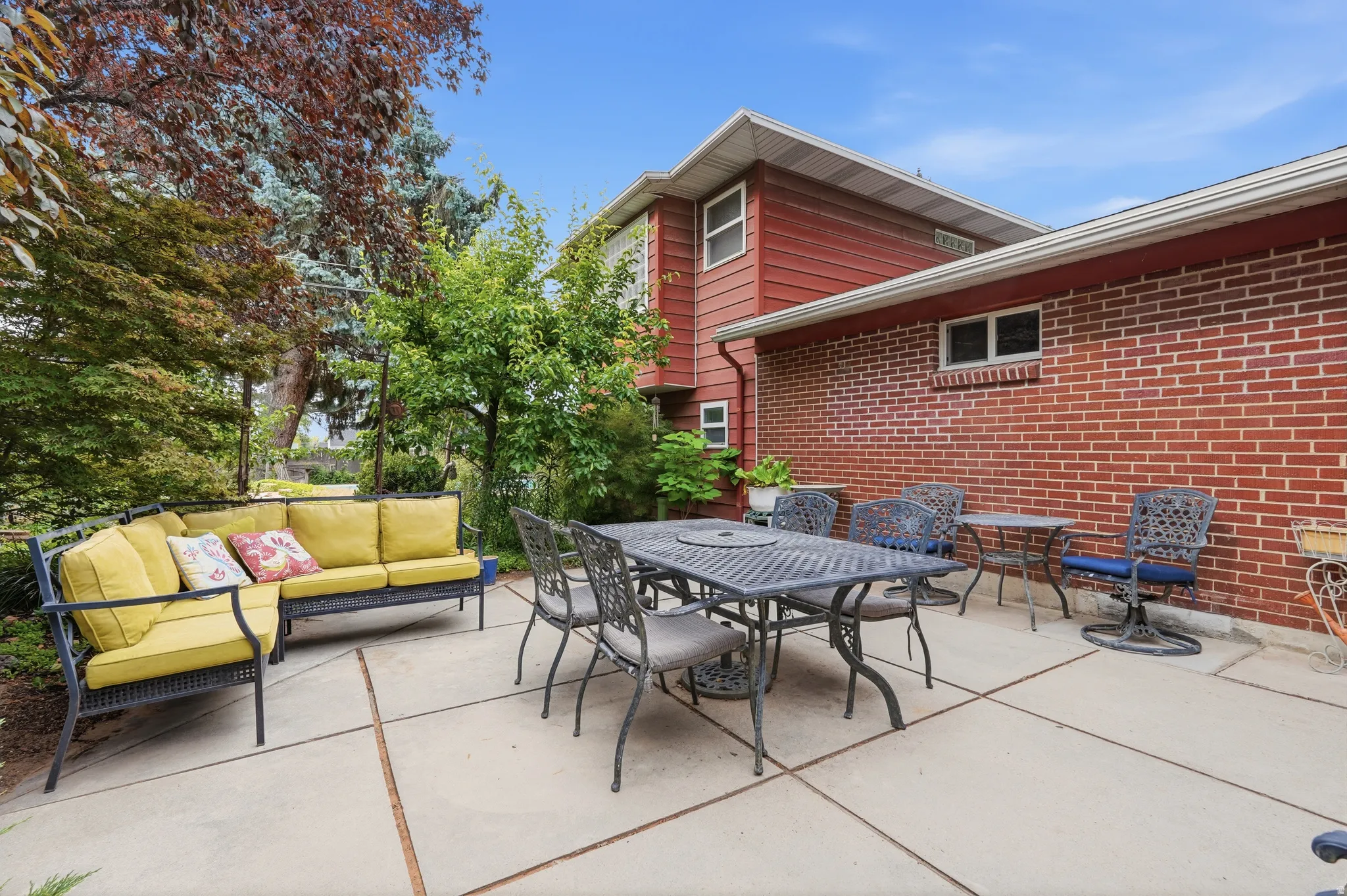 Expansive concrete patio with brick and siding exterior