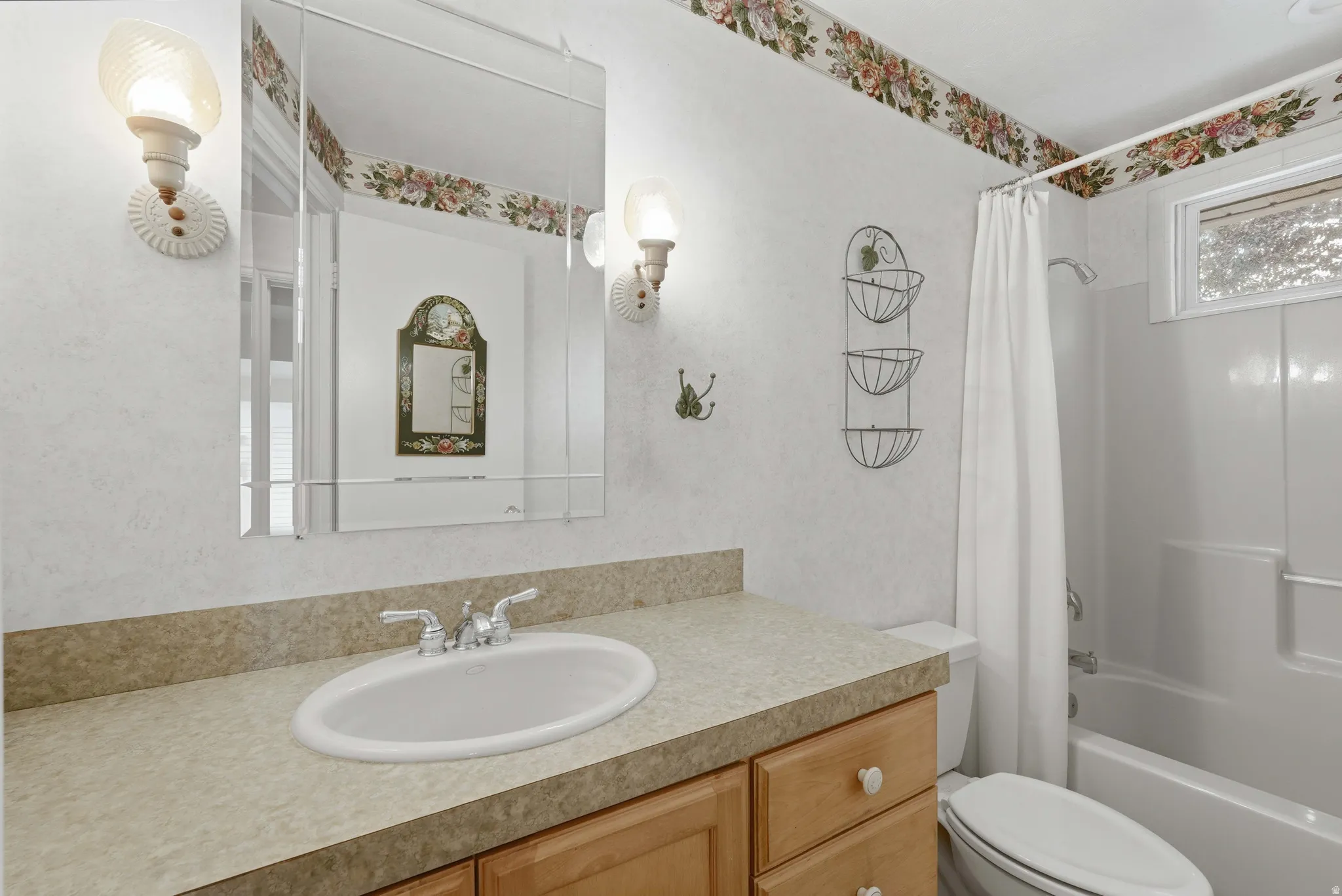 Bathroom featuring a vanity with a laminate countertop, an oval sink, and a mirrored medicine cabinet