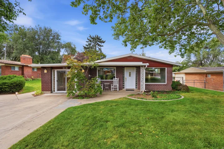 Brick facade home with a red trim roofline and a well-maintained front lawn