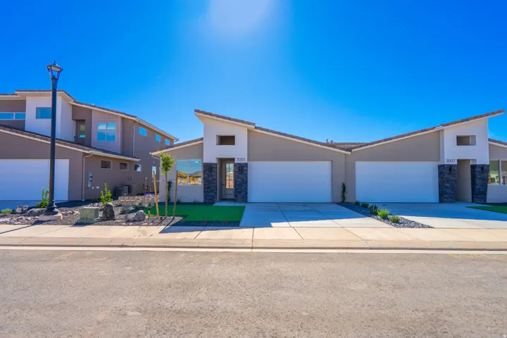 Mid-century home featuring stone siding, driveway, and a garage