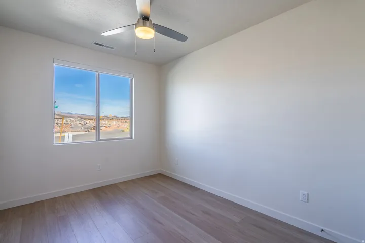 Empty room with ceiling fan and light wood finished floors