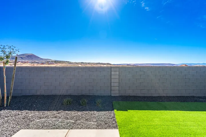 Exterior view of a mountain backdrop and a fenced backyard