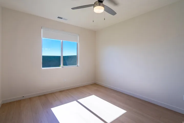 Spare room with light wood-type flooring and a ceiling fan