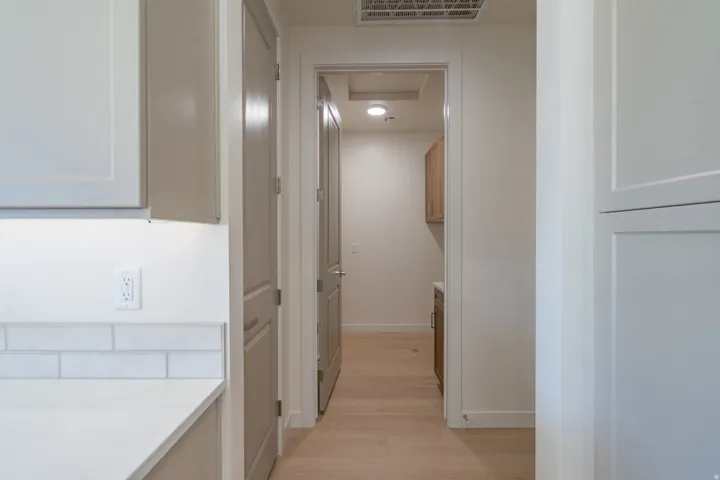 Corridor with baseboards and light wood-style floors