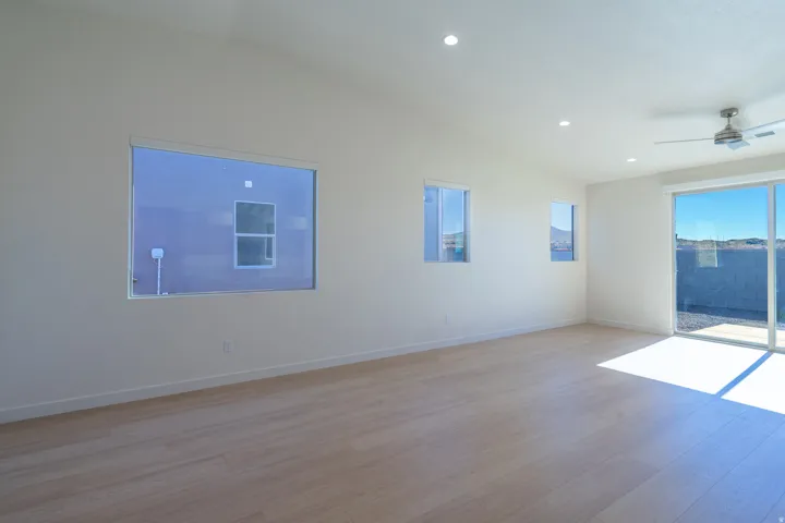 Spare room with lofted ceiling, ceiling fan, light wood finished floors, and recessed lighting