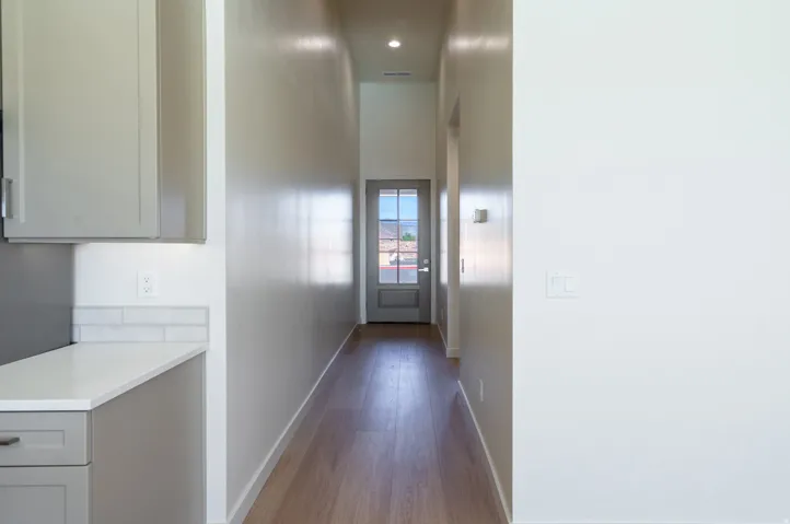 Corridor with dark wood-style flooring and recessed lighting