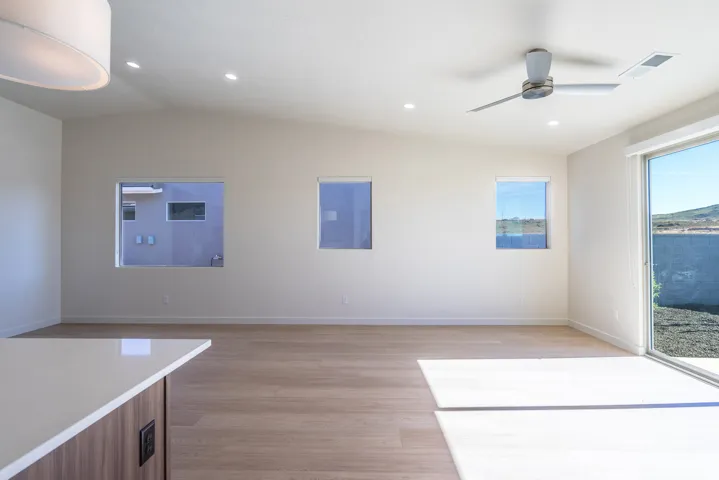 Unfurnished dining area with vaulted ceiling, light wood-style floors, ceiling fan, and recessed lighting