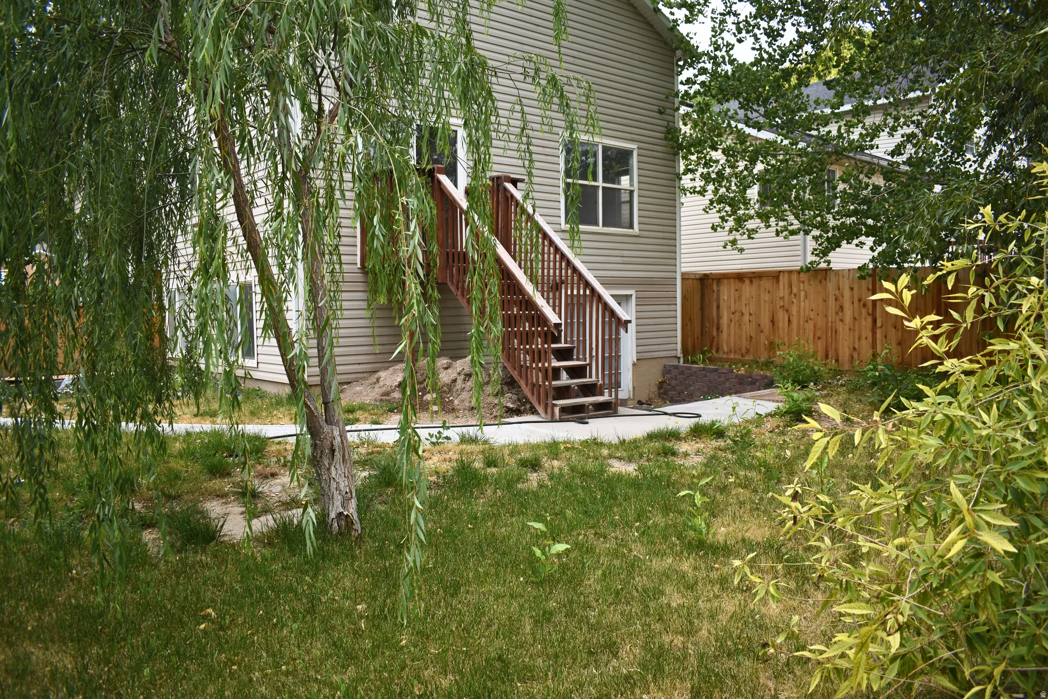 Rear exterior of the property featuring horizontal siding and a two-story wooden deck with stairs