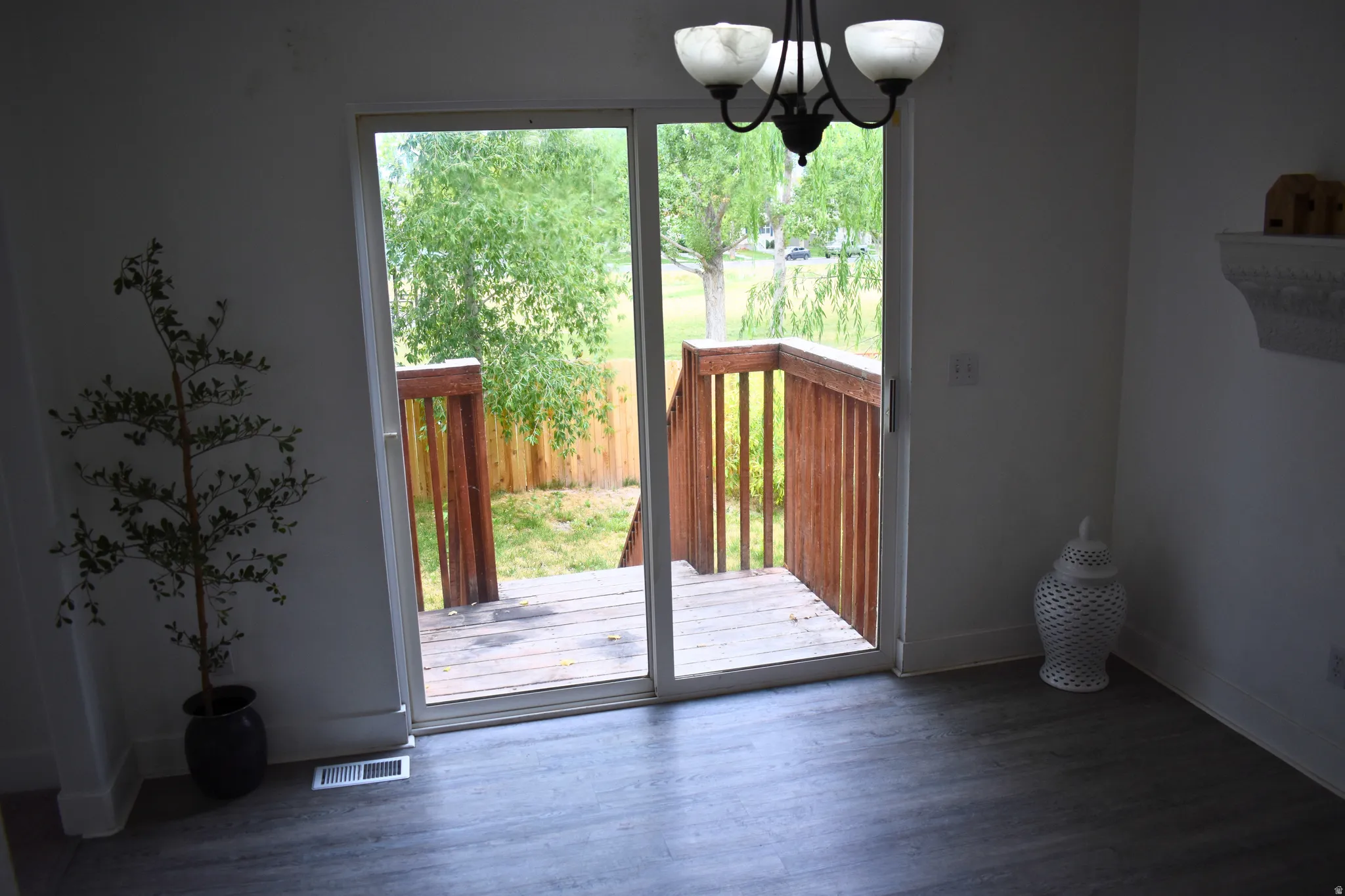 Sliding glass doors opening to an exterior wood deck with wood railings, offering outdoor access