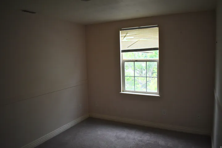 Single window with white trim, gray carpet flooring, and a baseboard molding