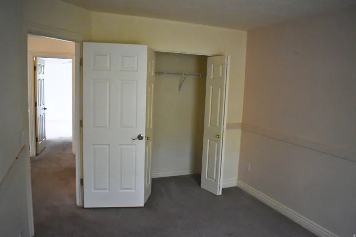 Room with neutral-toned walls, gray carpet flooring, and white baseboards