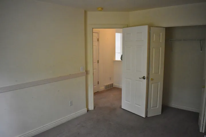 Carpeted room with neutral-toned walls, white baseboards, and a chair rail