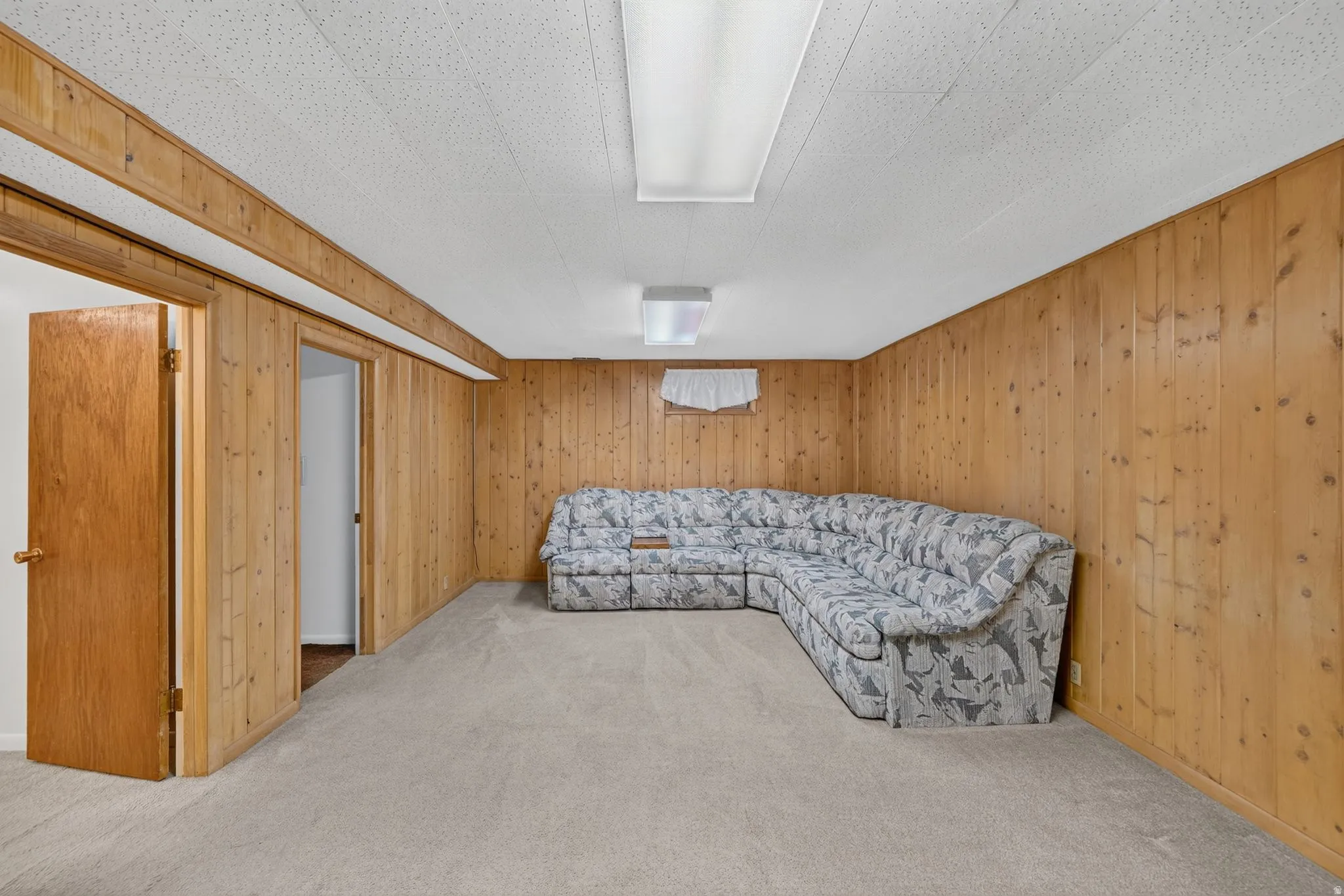 Wood-paneled room with light-colored carpeting