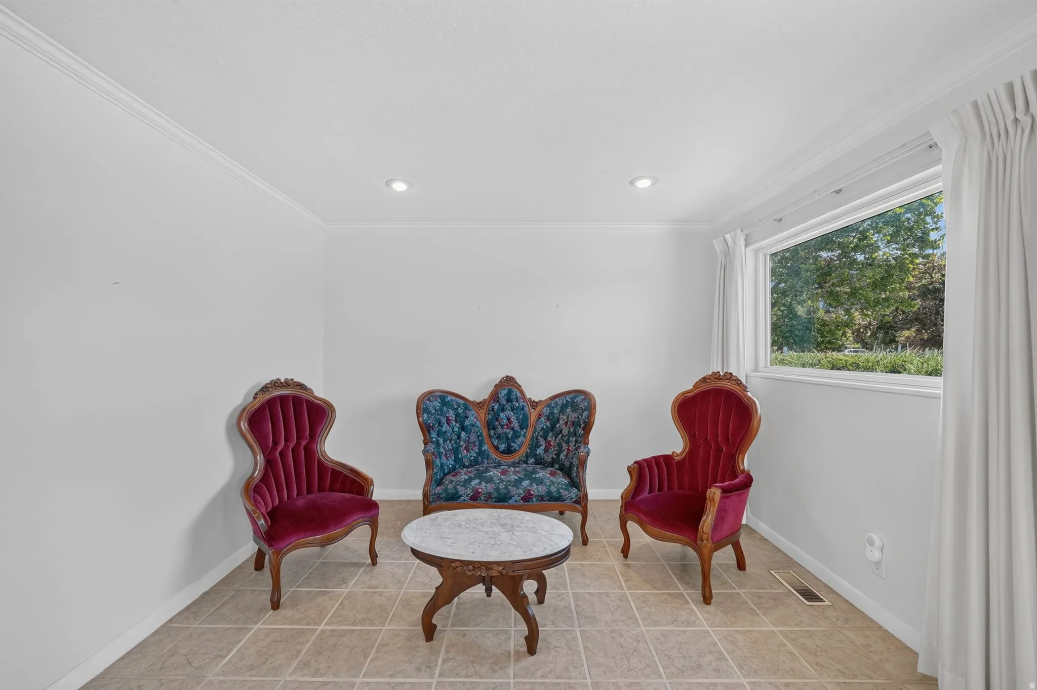 Bright room featuring tile flooring, a large window, recessed lighting, and crown molding
