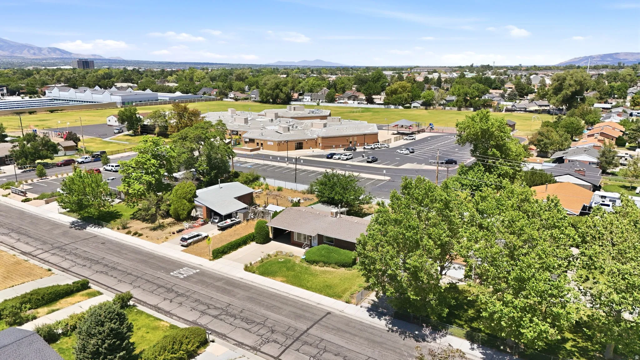 Aerial perspective showcasing residential properties and a commercial building with a large parking area