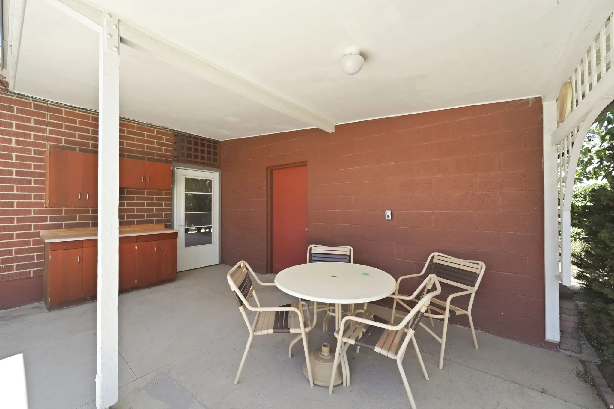 Covered patio area featuring a concrete floor and a white overhead structure