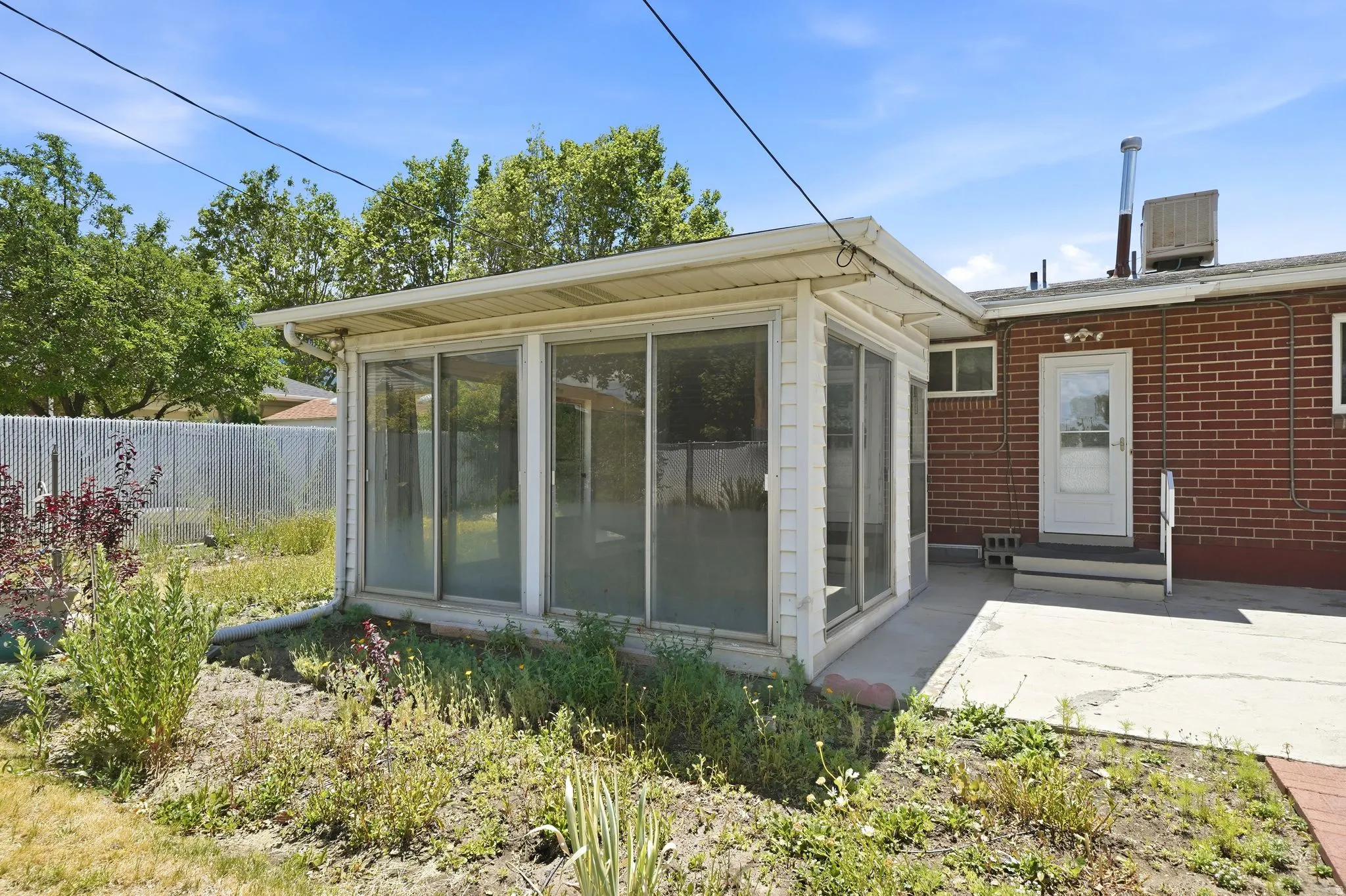 Sunroom addition featuring multiple window panels and an exterior gutter system