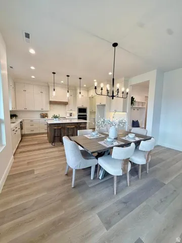 Open-concept kitchen and dining area featuring light wood-finish flooring