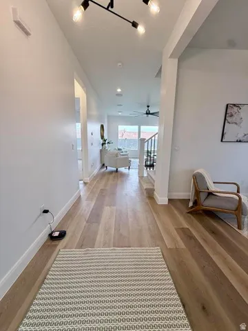 Open concept interior with light wood-finish flooring, recessed lighting, and a modern track lighting fixture