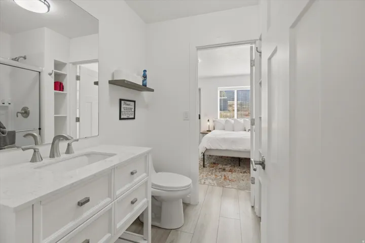 Bathroom featuring a white vanity with a rectangular undermount sink, brushed nickel faucet, and white countertop