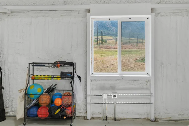Dual-pane window with white frame, set within a textured white wall, offering a distant mountain landscape