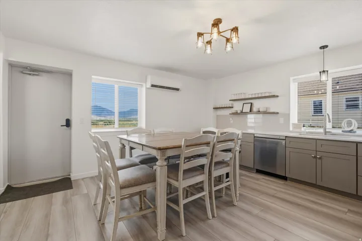 Bright interior featuring light wood-finish flooring, a contemporary ceiling light fixture, and a window with mountain scenery