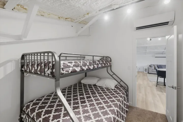 White walls featuring exposed ceiling beams and recessed lighting