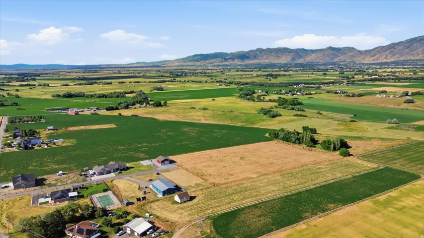 Expansive agricultural landscape featuring green fields, cultivated land, and distant mountains