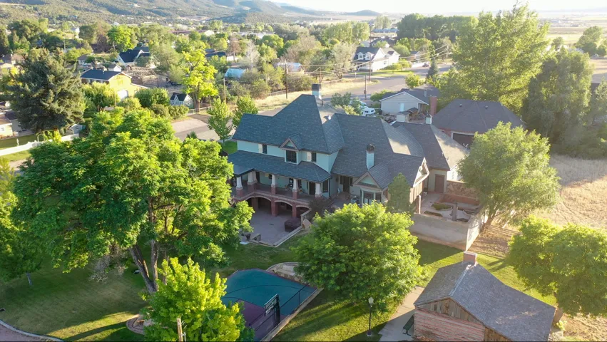 Expansive property featuring a multi-story residence with a covered front porch and a private rear patio