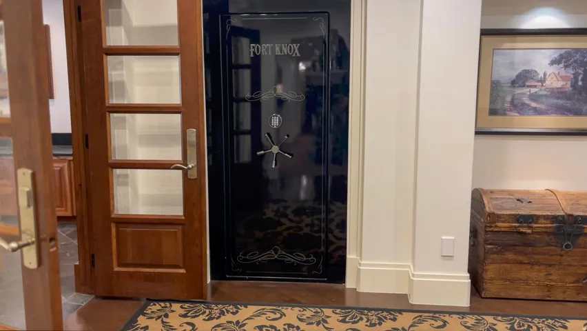 Custom black security vault door with combination lock and decorative detailing