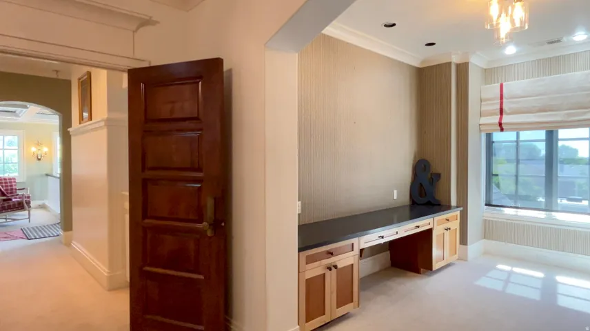 Built-in desk cabinetry with a dark countertop and light wood-finish doors