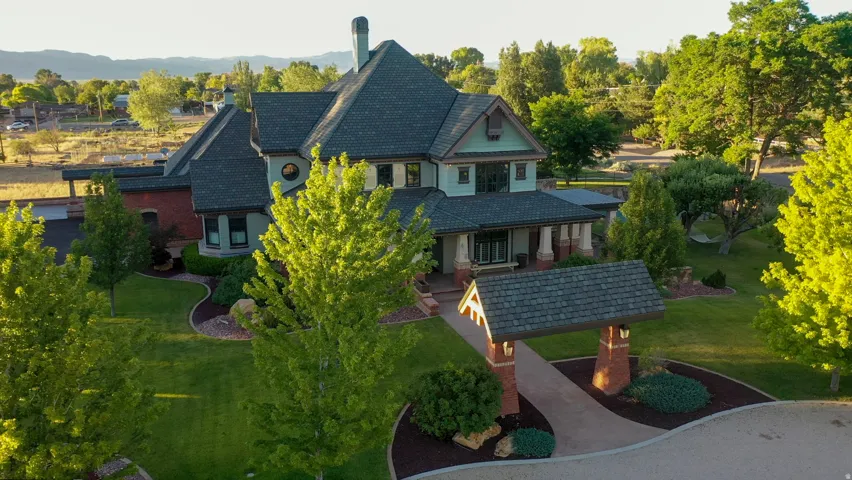 Stately multi-story residence featuring a distinctive shingle roof and brick accents