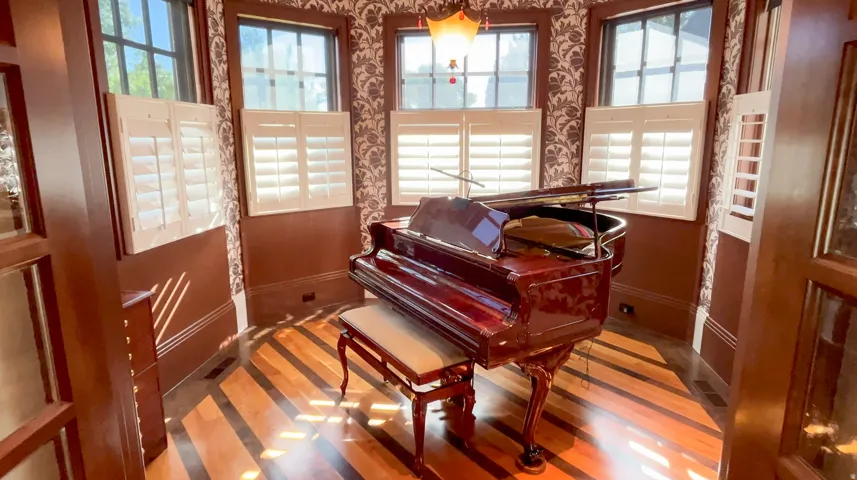 Bay window area featuring plantation shutters and a patterned wall covering