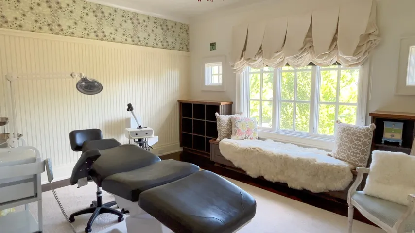 Room featuring a broad bay window with a built-in window seat, beadboard wall paneling, and decorative wallpaper border