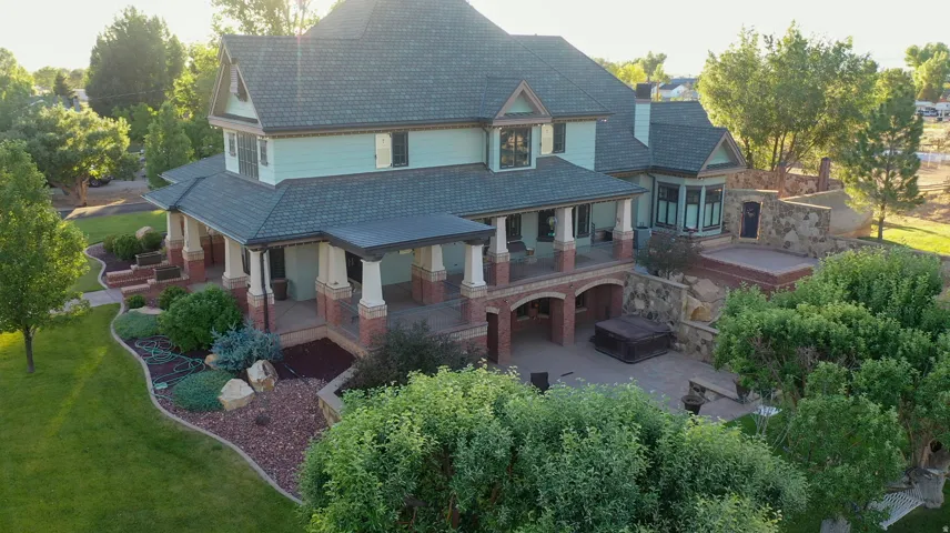 Expansive property featuring a multi-level structure with a covered porch and lower-level patio