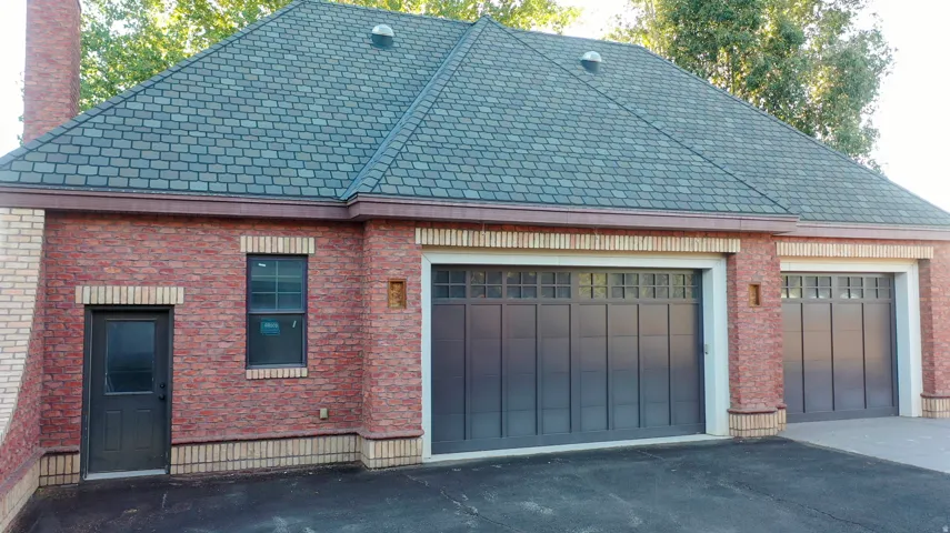 Brick exterior with complementary light-colored brick accents, featuring a dark shingle roof
