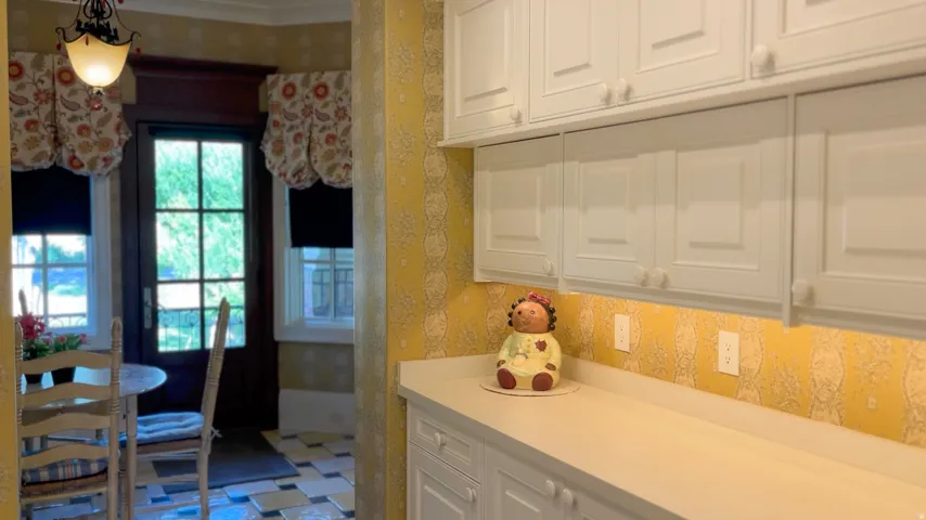 White cabinetry with integrated hardware, light-toned countertops, and a patterned backsplash