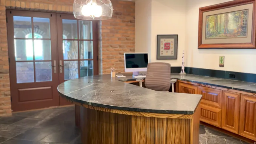 Custom built-in desk with a stone countertop and wood-finish cabinetry