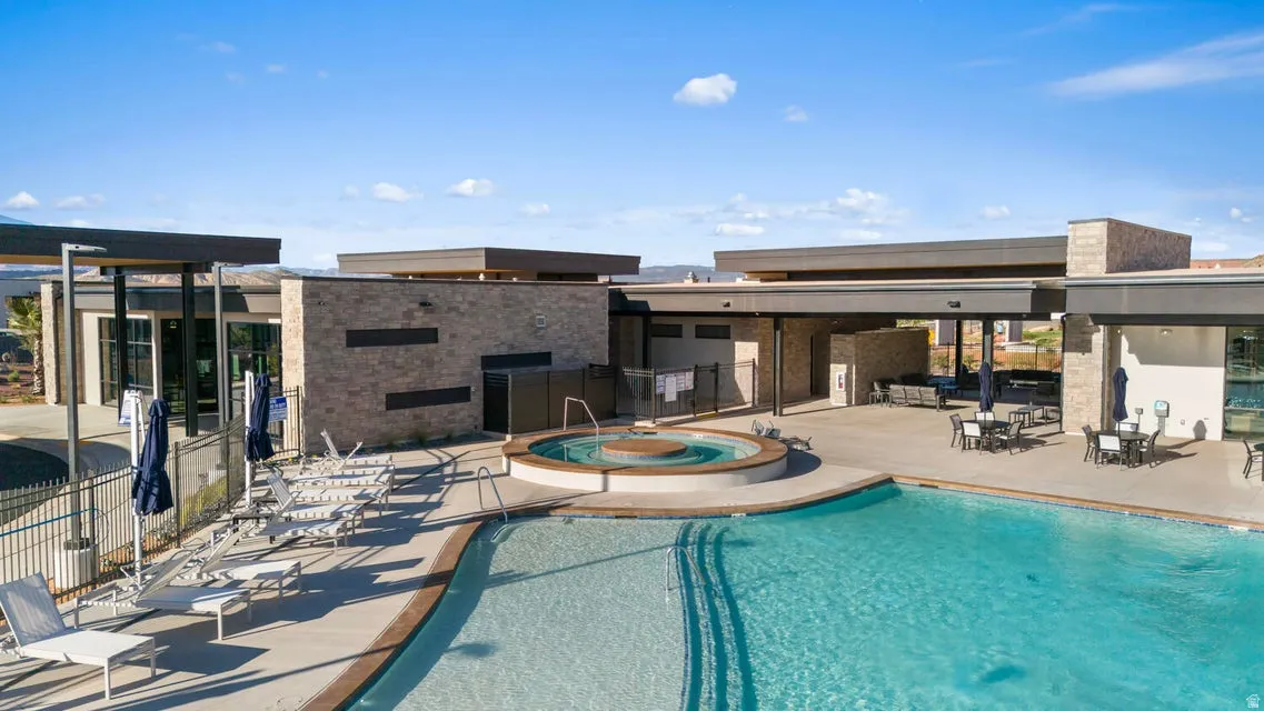 Resort-style pool area featuring an expansive swimming pool and an integrated spa