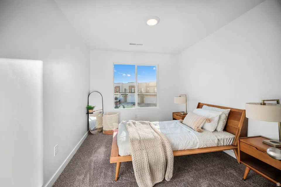 Bright interior room featuring a large window, carpet flooring, recessed lighting, and white wall finishes