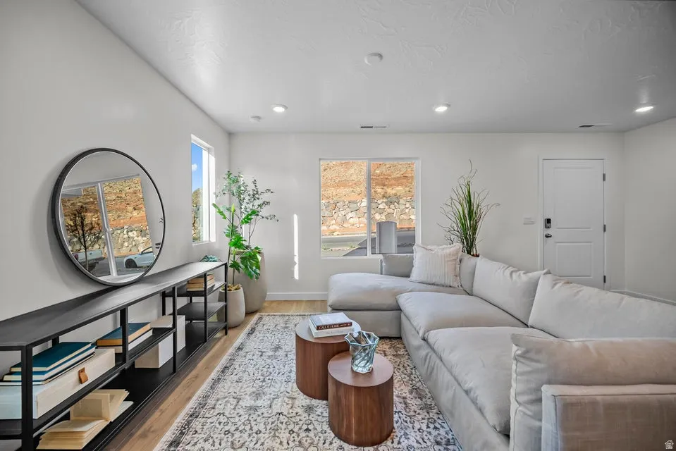 Bright living area featuring wood-finish flooring, recessed lighting, and white walls