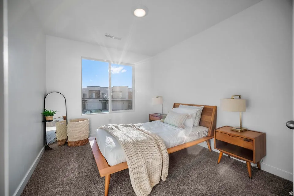 Bright interior space featuring a large window, plush carpet flooring, and recessed ceiling lighting
