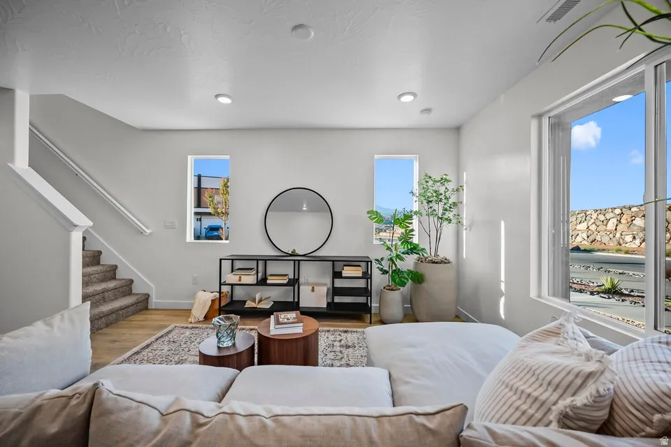 Living area featuring wood-finish flooring, recessed lighting, and large windows