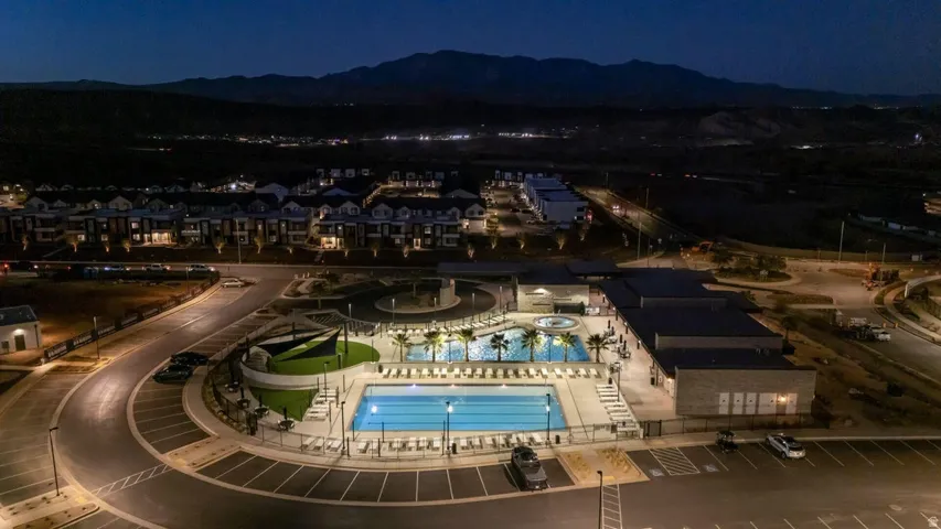 Community recreation area featuring multiple pools, spa, and mature palm trees