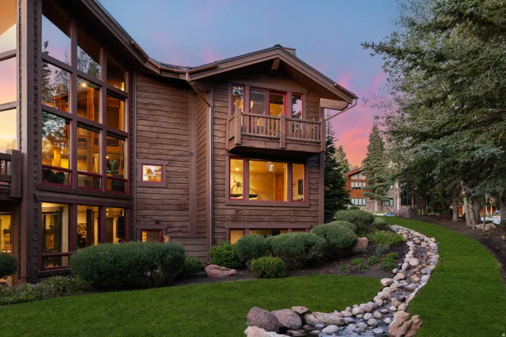 Wood-clad exterior with extensive window features and a second-story balcony