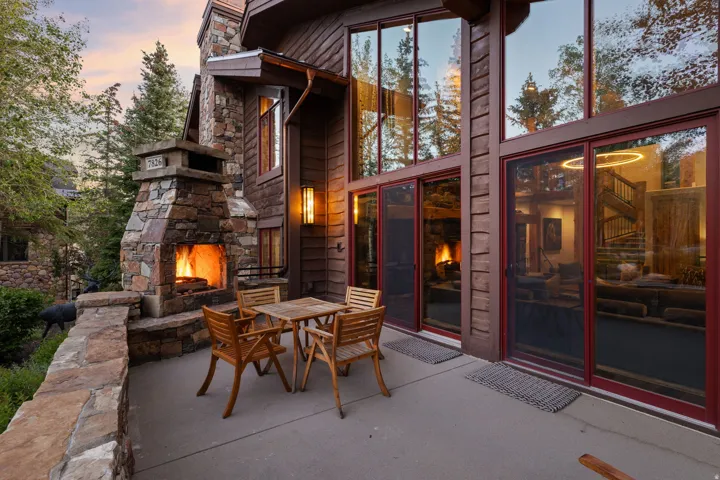 Outdoor stone fireplace with a stone chimney and stone wall cap