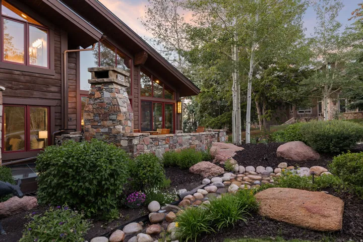 Log-sided exterior featuring extensive stonework and large windows
